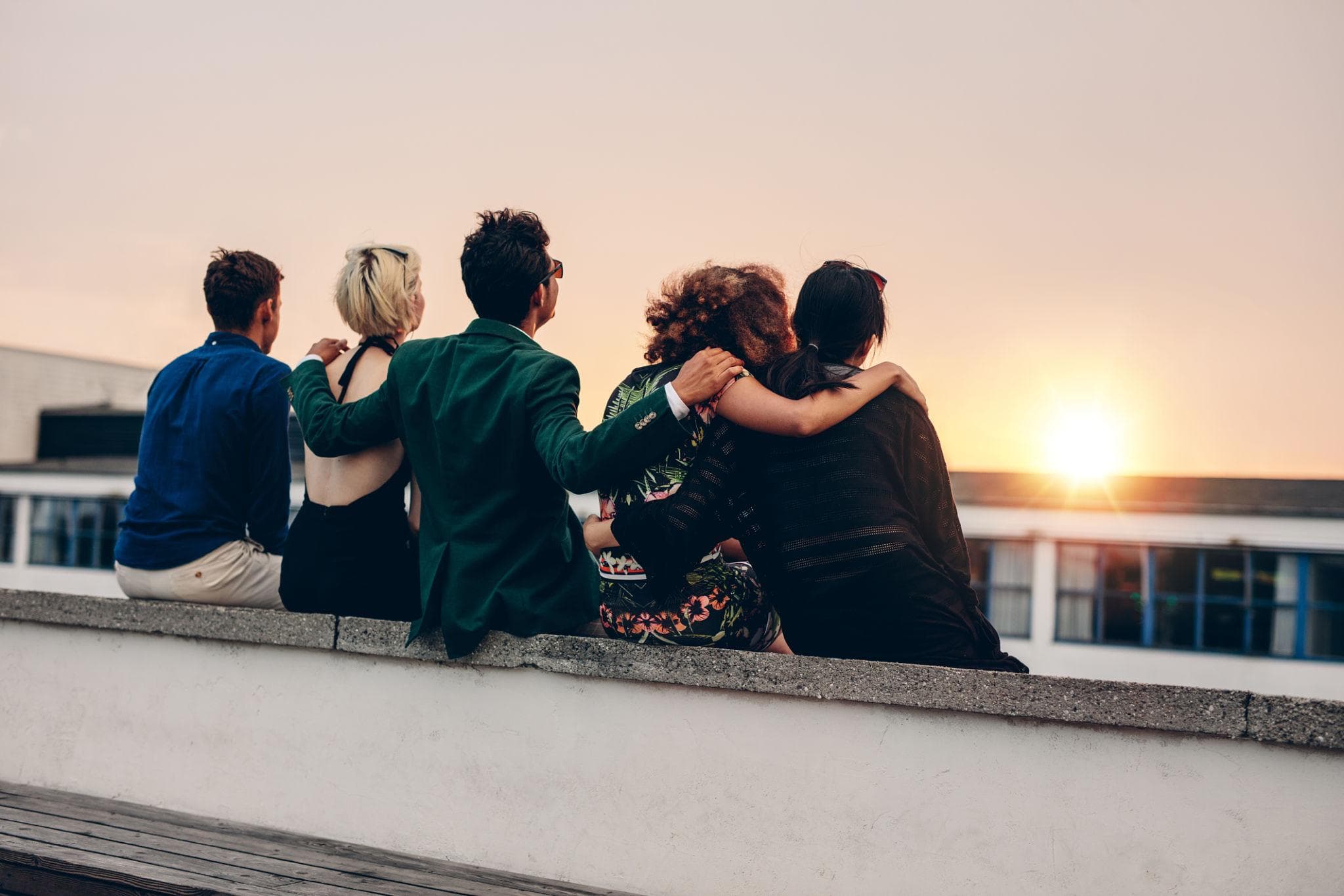 Un groupe de personnes réunies et solidaires face au coucher du soleil
