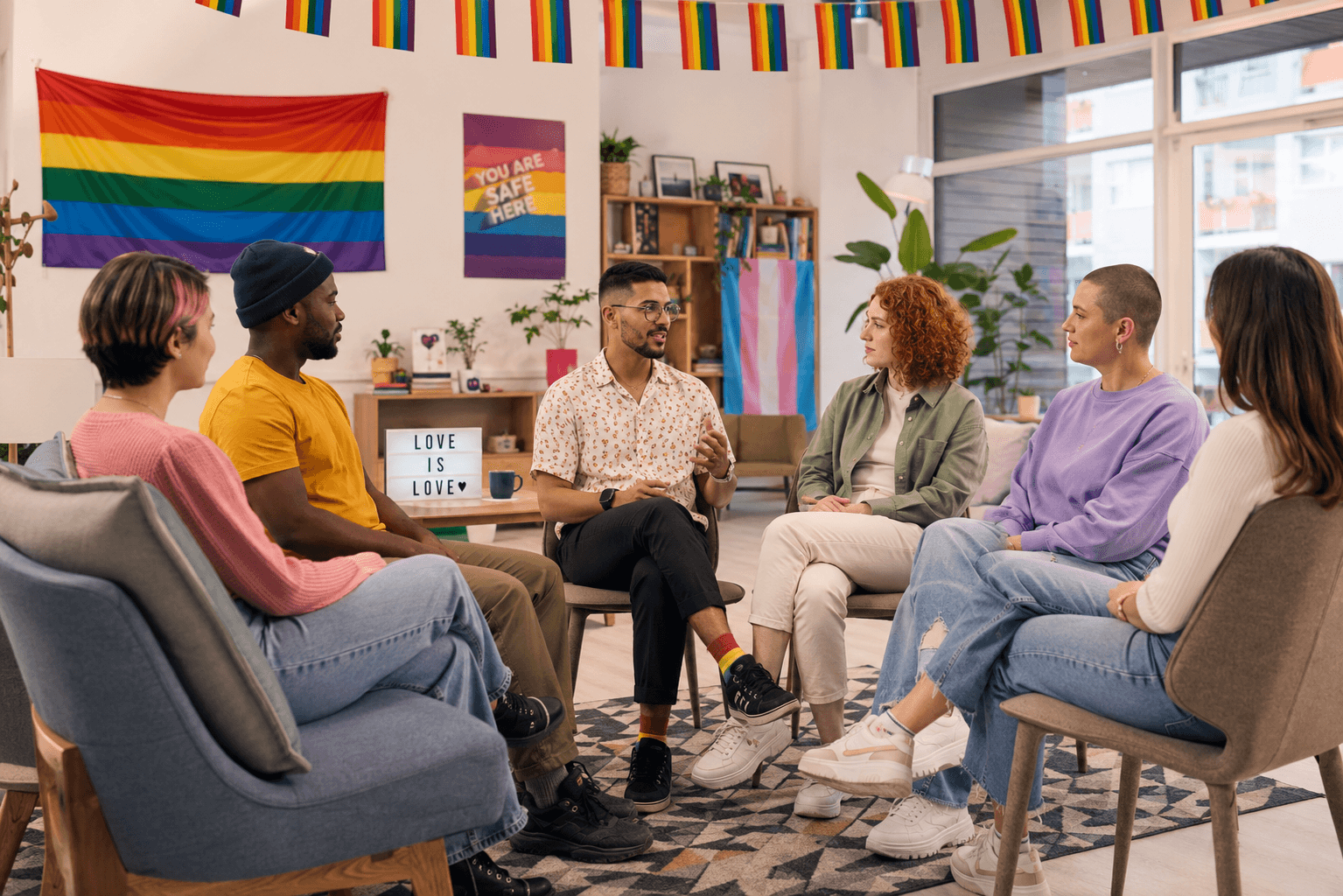 Un groupe de personnes LGBTQIA+ réuni dans un espace d’écoute et de discussion